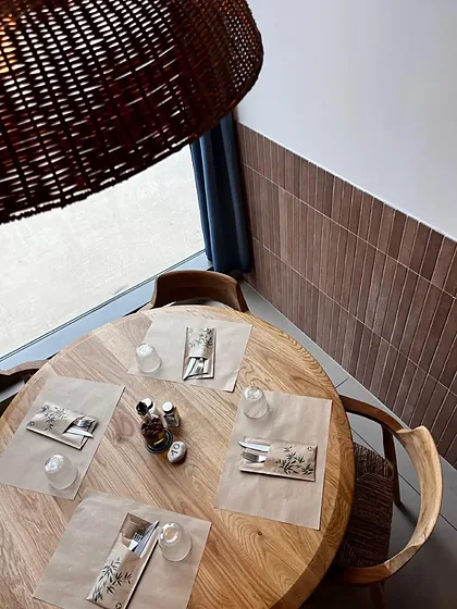 Table ronde dressée vue de dessus, sets kraft, huile d'olive, suspension osier